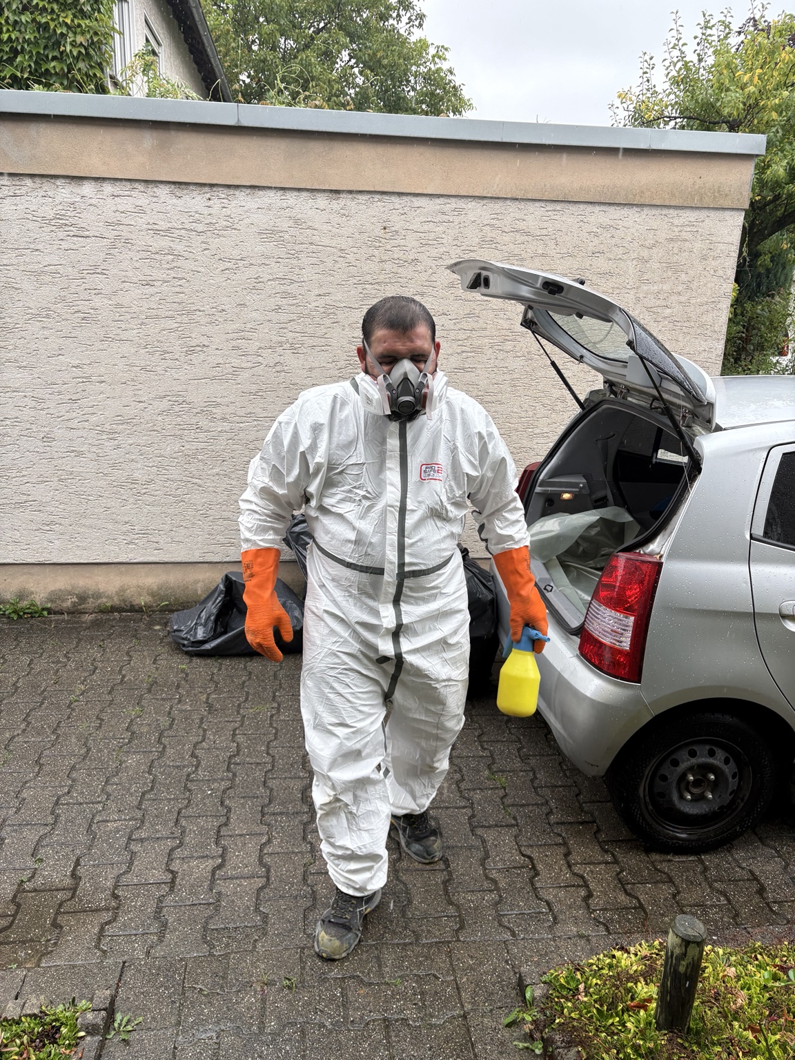 MORK-Mitarbeiter in Schutzkleidung und mit Atemschutz im Außenbereich