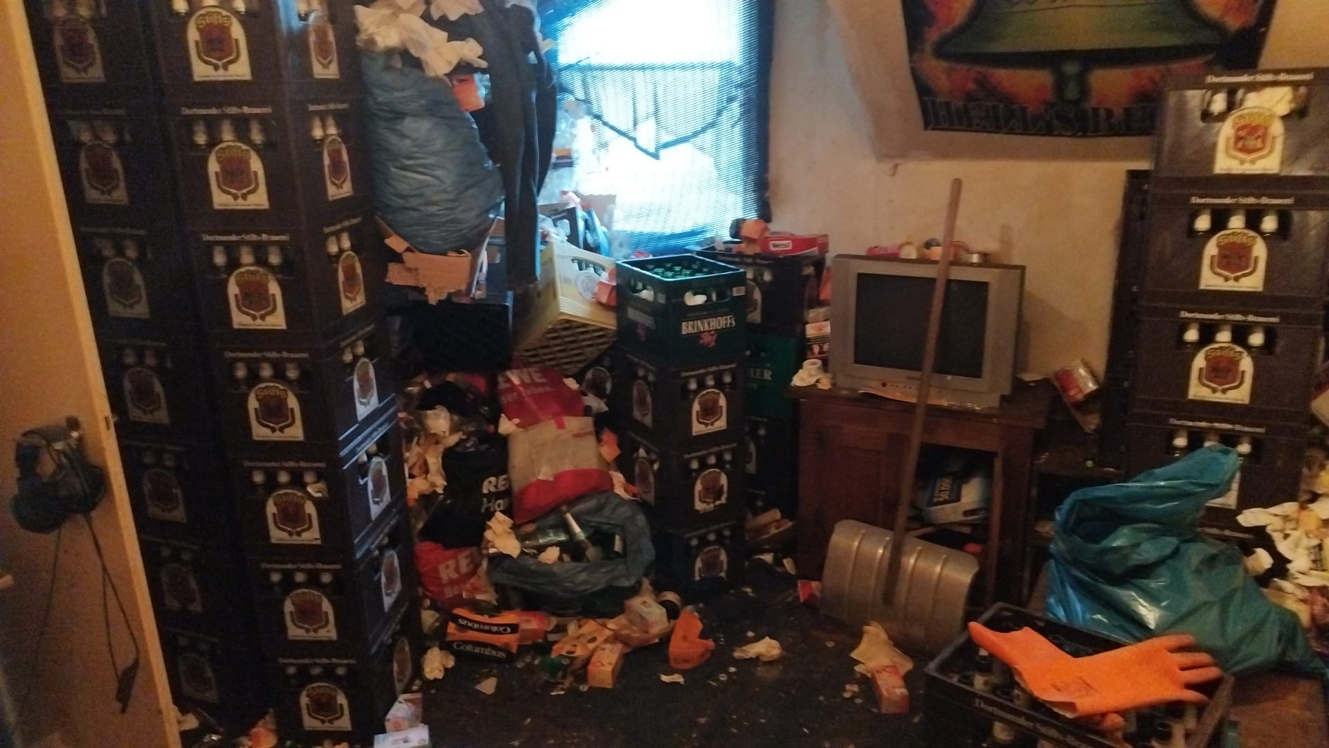 Stark zugestellter Raum mit Getränkekisten vor der Räumung durch MORK